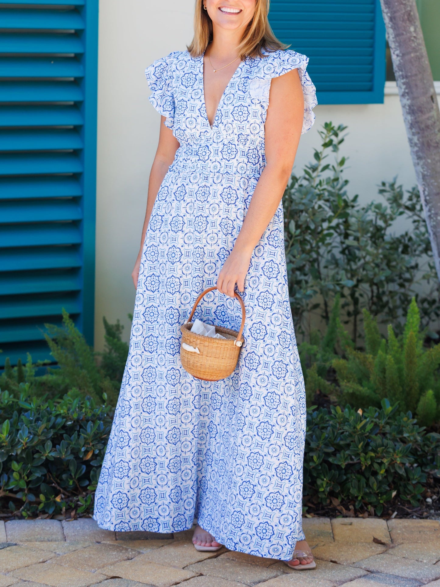 Vestido largo con medallón azul, escote en V y mangas onduladas